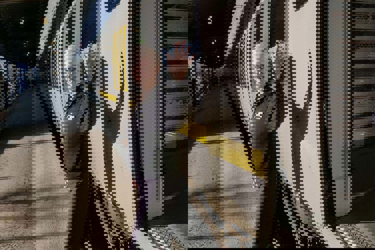 Sara står utanför tåget och vinkar adjö.