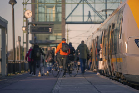 Resenärer går av ett tåg på en tågperrong